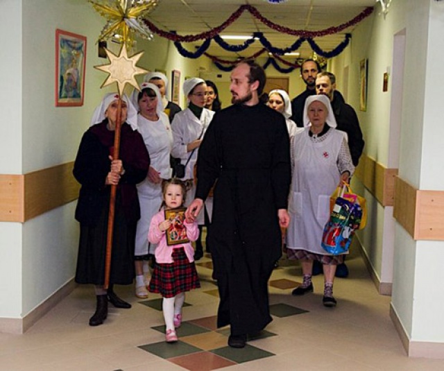 Отец Николай вместе с сетрами училища поздравляет пациентов в больнице с Рождеством Христовым